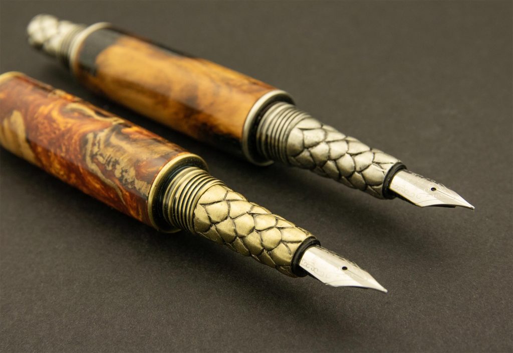 Two handmade wooden fountain pens with a dragon scales design.