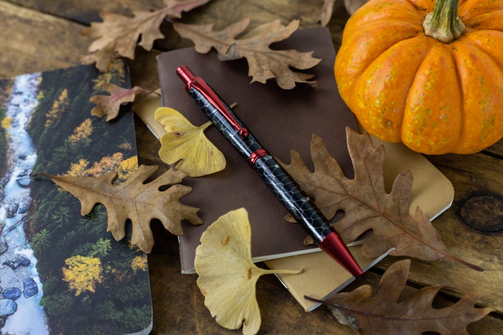 Slim Max 2.0 Click Pen Kit in Red from William Wood-Write turned with "Python" Honeycomb pen blank against fall background.