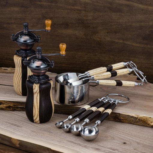 Wood turned salt and pepper shakers and spoons made of segmented dark and light wood.