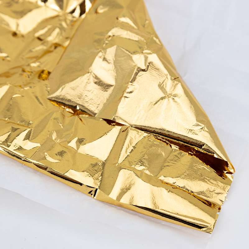 A rectangular sheet of gold foil folded in one corner.