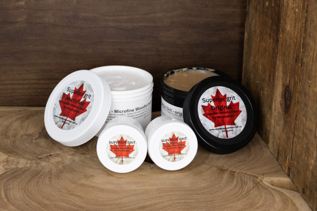 A selection of black and white containers of abrasive pastes for wood turning with red Canadian maple leaf logos.