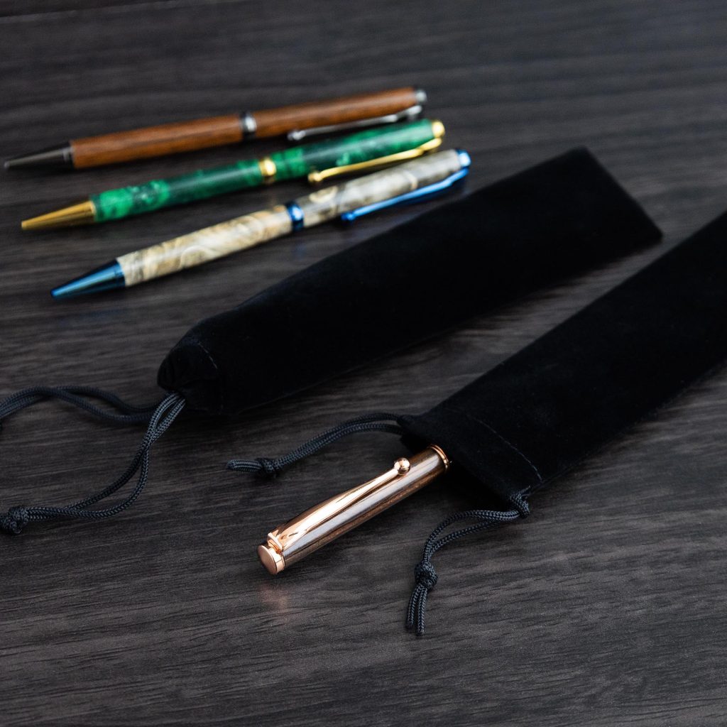 An assortment of handmade pens in various colours with black storage pouches