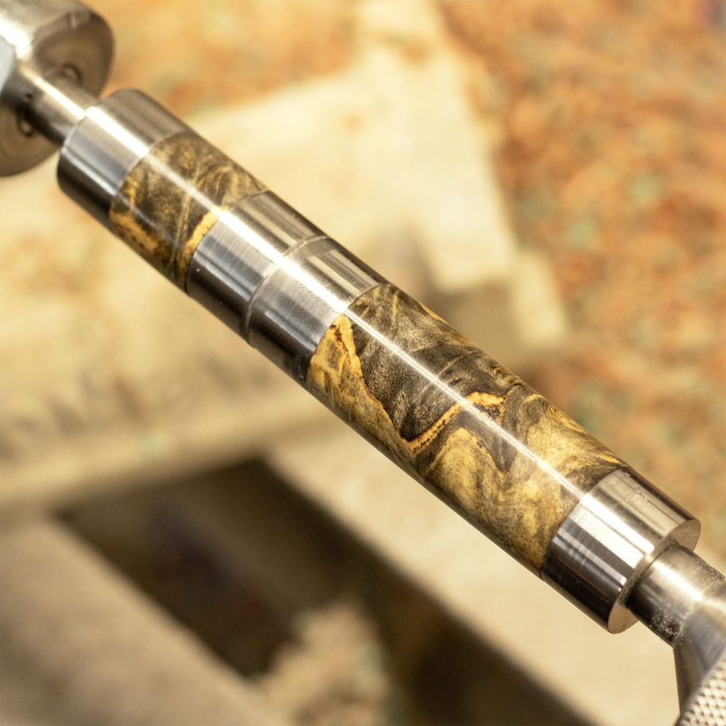 A lathe with finished buck eye burl pen barrels on it