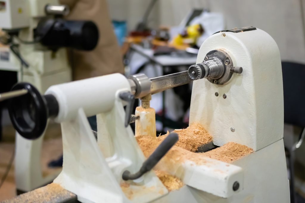 Wood turning lathe machine with shavings in a workshop