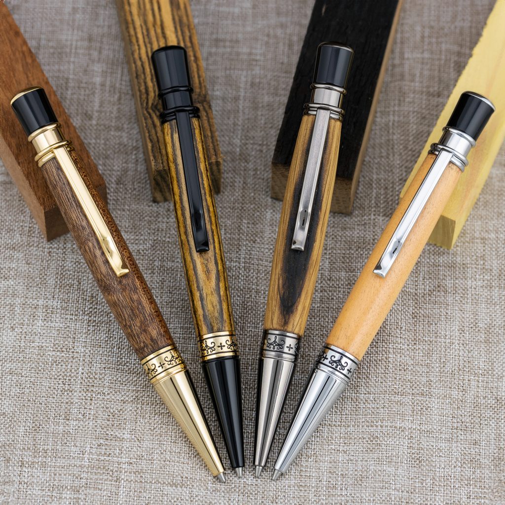 Four handmade pens in gold, black chrome, gun metal and chrome, made out of wood on a lathe