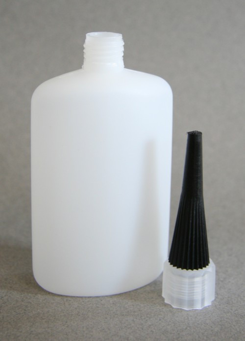 A white bottle with a black lid beside it