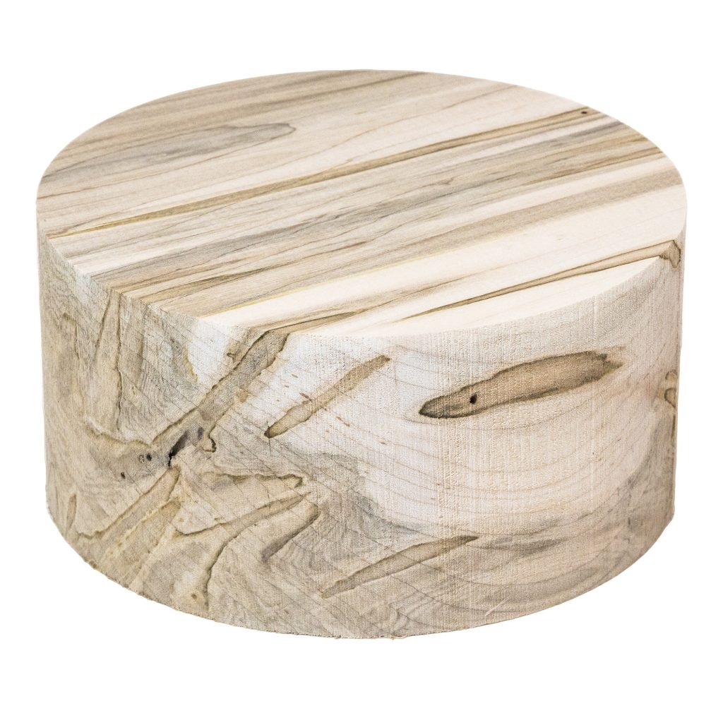 A round peice of wormy maple wood for bowl turning that is light beige with dark coloured streaks in it.