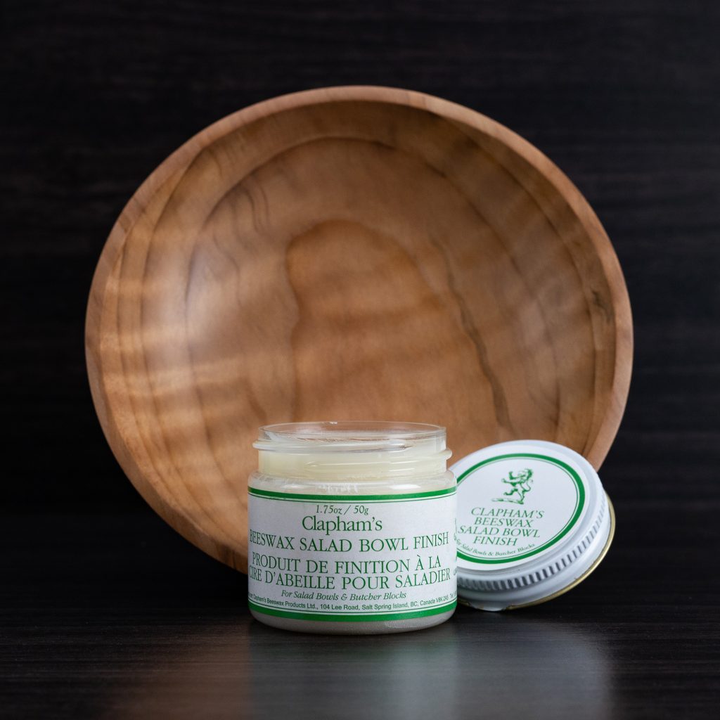 A wooden bowl with a jar of natural wax wood finish